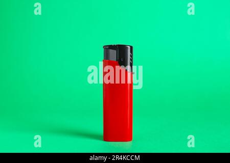 Stylish small pocket lighter on green background Stock Photo