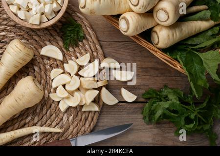 Whole and cut parsnips on wooden table, flat lay Stock Photo