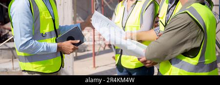 Team group of contractor and architect with foreman explaining about scheme building site for planning project to worker and looking blueprint, constr Stock Photo