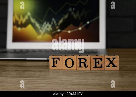 Word Forex made with cubes and laptop on wooden table Stock Photo