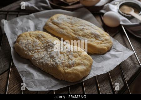 Raw dough for ciabatta and flour on wooden table Stock Photo