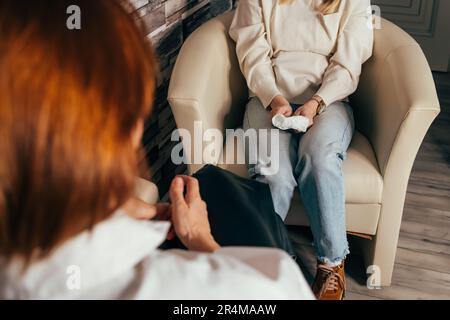 Psychotherapist taking notes during conversation with depressed female Stock Photo
