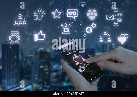 Woman's hands with smartphone and social networking icons on background of night city. Concept of global mobile communication and social networks Stock Photo