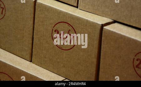 24 by 7 24 hour a day service stamp printed on cardboard box. 24h round the clock concept. Stock Photo