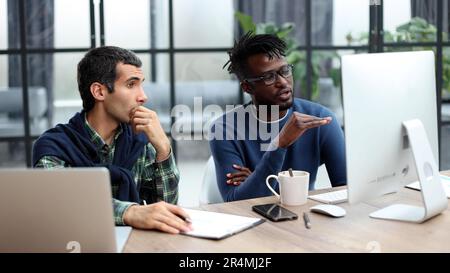 Business people working together in a modern trendy office behind a laptop Stock Photo