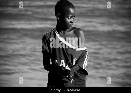 A portrait of a young African boy contemplating the beach after fishing, in Beira, Mozambique. Stock Photo