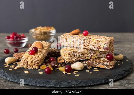 Various granola bars on table background. Cereal granola bars. Superfood breakfast bars with oats, nuts and berries, close up. Superfood concept. Stock Photo