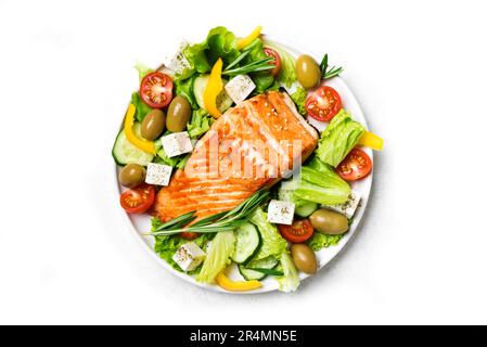 Fresh greek vegetable salad with green olives and feta cheese and grilled salmon fish steak isolated on white background. Healthy balanced food concep Stock Photo