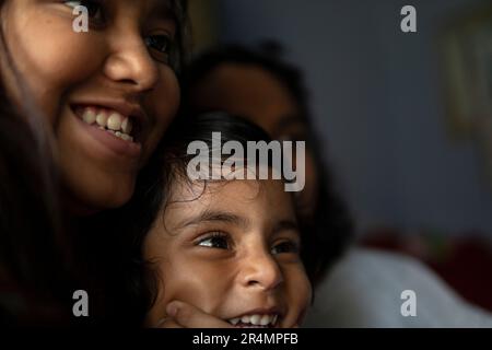 Three sisters making fun and laughing inside home Stock Photo