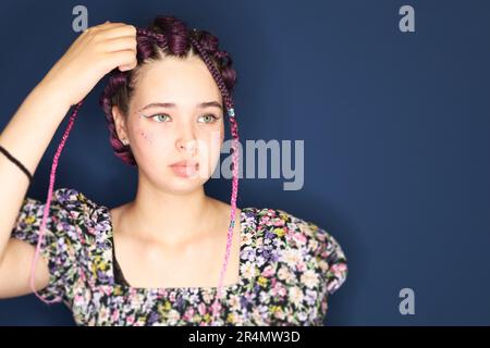girl with brown hair and pigtails braided with artificial hair braiding. Stock Photo