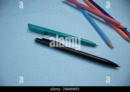 Colored pencils photographed from above, superimposed on a blue background. Stock Photo