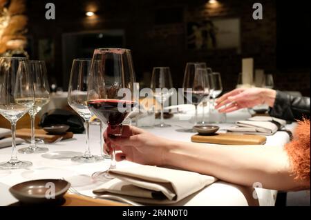 Woman holding a glass with red wine with lipstick marks Stock Photo