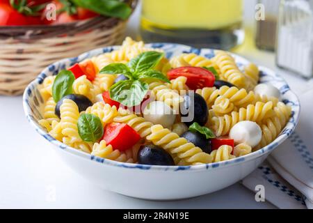 Italian cold pasta salad or Pasta fredda alla caprese. Directly above. Fusilli, tomato, mozzarella, olive, arugula. Turkish name; burgu makarna salata Stock Photo