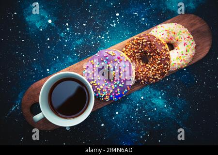 Assorted donuts and a cup of coffee on a space background. Stock Photo