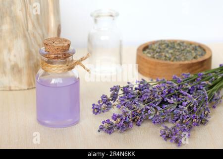 Dry lavender flowers in wooden bowl and bottle of essential lavender oil or  infused water on white background. Natural organic ingredients for herbal  Stock Photo - Alamy