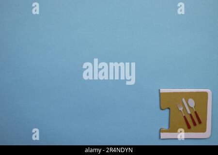Picture puzzles placed on the edge of the blue background. Kitchen set. Stock Photo