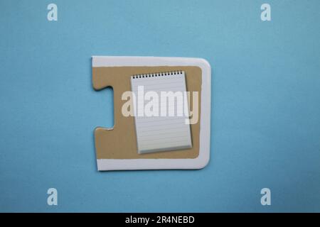 Picture puzzles placed on a blue background. Notepad Stock Photo