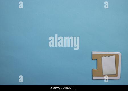 Picture puzzles placed on the edge of the blue background. Notepad Stock Photo