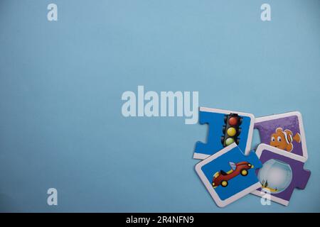 Picture puzzles placed on the edge of the blue background. Traffic signs, car, fish and fishbowl. Mixed. Stock Photo