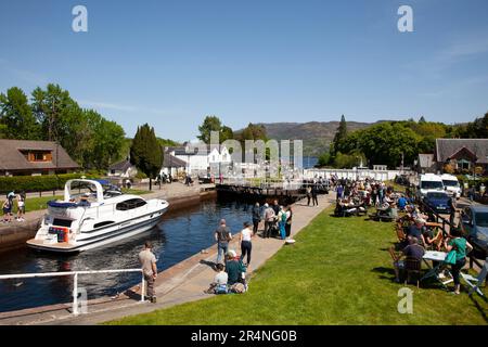 Fort Augustus, Highland, Scotland, UK, 29th May 2023. Busy bank holiday Monday by the Caledonian Canal locks with hundreds of tourists milling around and watching the vessels pass through the locks. Temperature 16 degrees centigrade mid-afternoon. Pictured: Kintail 1V passes through the locks in the canal and finally the swing bridge. Stock Photo
