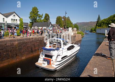 Fort Augustus, Highland, Scotland, UK, 29th May 2023. Busy bank holiday Monday by the Caledonian Canal locks with hundreds of tourists milling around and watching the vessels pass through the locks. Temperature 16 degrees centigrade mid-afternoon. Pictured: Kintail 1V passes through the locks in the canal and finally the swing bridge. Stock Photo