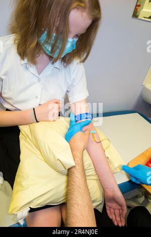 Blood test being performed on a young teenage girl / girls arm / blood being taken for testing by a blood phlebotomist in a paediatric hospital ward. London. UK. (134) Stock Photo