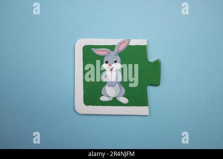 Information puzzles, photographed from above, placed on a blue background. Happy white rabbit. Stock Photo