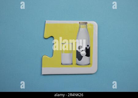 Information puzzles placed on a blue background. Milk in a glass and bottle. Stock Photo