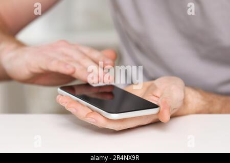 A man cleans the phone screen to stick a protective tempered glass. Broken protective glass Stock Photo