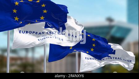 Frankfurt, DE, March 2023: Three Flags of the European Central Bank and European Union waving in the wind with the ECB seat blurred on background. Ill Stock Photo