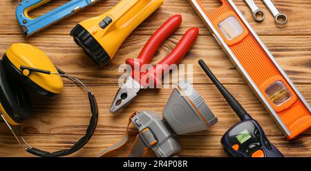 Construction tools with safety headphones and flashlights on wooden background Stock Photo