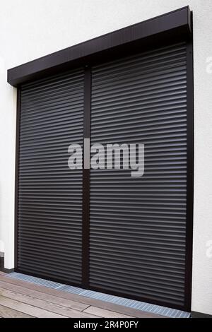 View of building with big windows and black roller shutters outdoors Stock Photo
