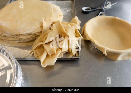 Artfully shaped short pastries and quiche tins, a tempting sight on a metal table from a side view Stock Photo