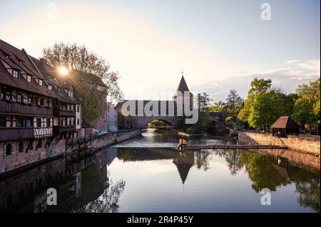 Sunset over old medieval bridge over Pegnitz river in Nuremberg, Germany. Fronveste and Schlayerturm tower. Stock Photo