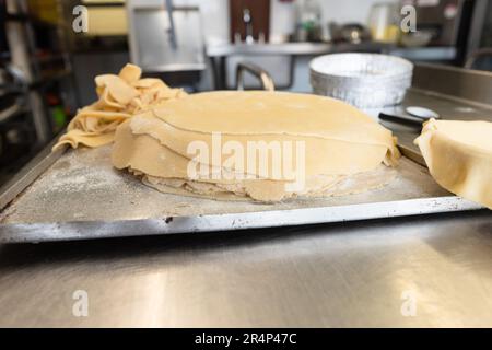Exquisite rolled pastry capturing the essence of a kitchen, accompanied by pastry tools and offcuts Stock Photo