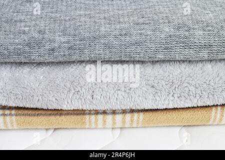 Three blankets: grey and beige on the mattress. Graphic resources Stock Photo