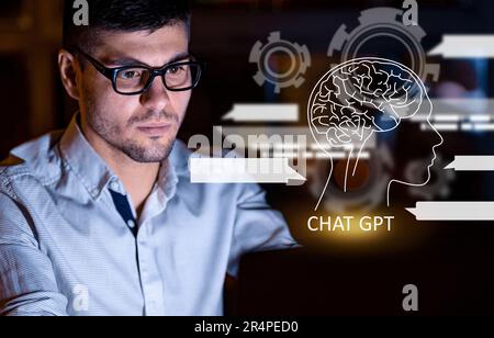 Young man wearing eyeglasses working on laptop, using chat gpt Stock Photo