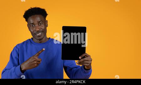 Handsome african american man pointing at pad with mockup Stock Photo