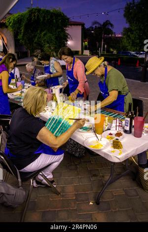 Men and women participate in an amateur outdoor painting art project at a Southern California Catholic church. Stock Photo