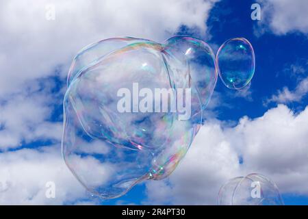 Soap bubbles against a blue sky and puffy white clouds Stock Photo