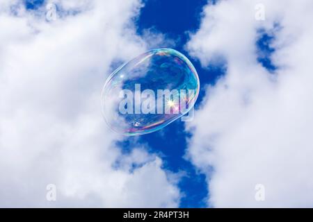 Soap bubbles against a blue sky and puffy white clouds Stock Photo