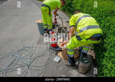 Bergamo Italy May 25th 2023: Workers who are laying the cables for the connection of the optical fiber Stock Photo