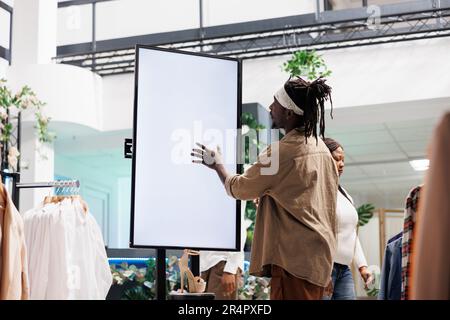 Customer interacting with digital smart board in clothing store Stock Photo