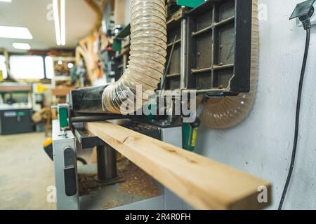 Carpenter using professional wood surface planer machine to produce flat surface. High quality photo Stock Photo