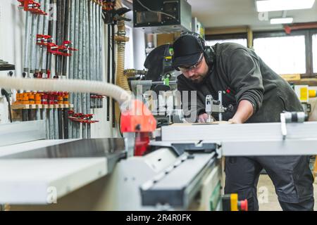 professional male carpenter working focused on his product, woodworking studio. High quality photo Stock Photo