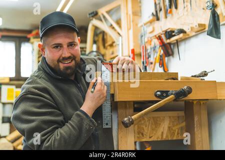 young craftsman using a set square marking a point and showing thumb up, medium closeup. High quality photo Stock Photo