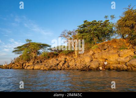 A man fishing on rocky shore of the Lake Baringo. Kenya, Africa. Stock Photo