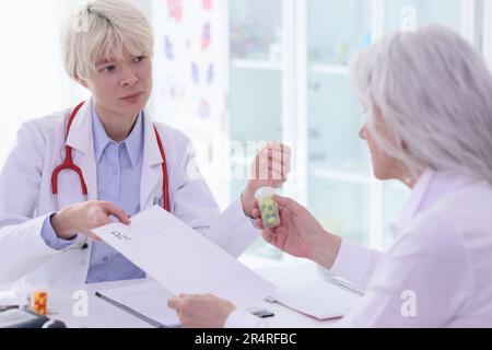 Therapist shows tests results and prescription to old woman Stock Photo