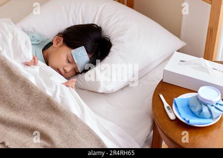 Japanese kid sick in bed Stock Photo