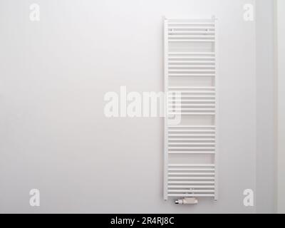 Battery for drying towels in the bathroom. Radiator on the wall. Stock Photo